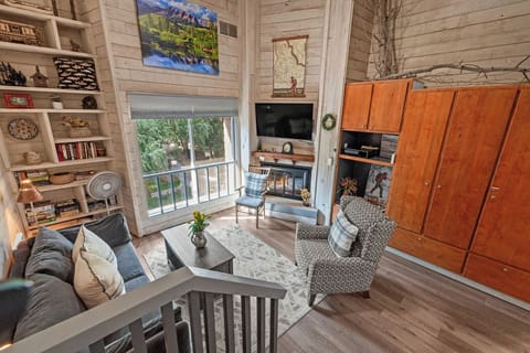 Cozy loft living room with tall windows, rustic charm, and relaxing seating