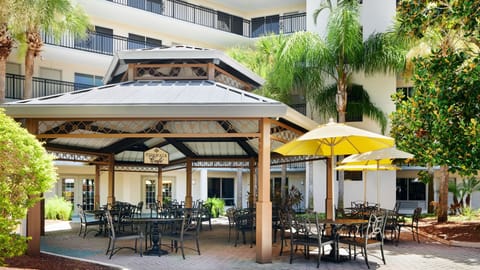 Outdoor seating under a shaded gazebo with tables.