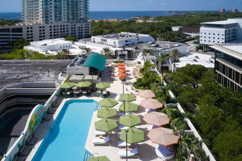 Take in panoramic views while relaxing by the rooftop pool, accentuated by vibrant umbrellas and tropical trees