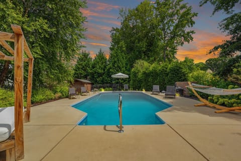 Private pool oasis with hammock, lounge seating, and stunning sunset views