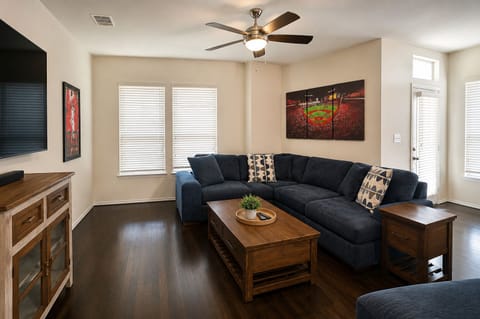 Spacious, bright living room with large sectional and stylish wood accents