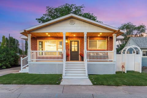 Charming cottage with a warm-lit porch and inviting curb appeal