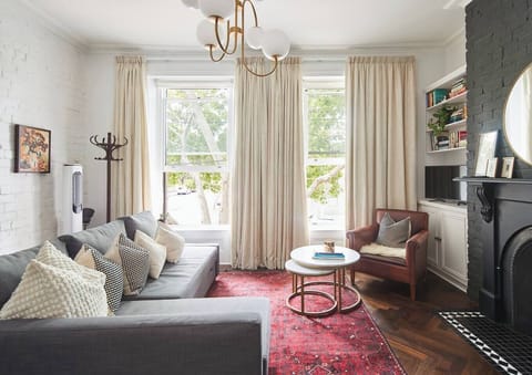 Settle into the bright living area where a comfortable sofa, TV and leafy outlooks create a relaxed place to unwind after a day exploring nearby Carlton Gardens.