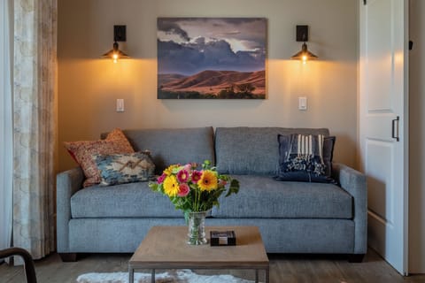 Layered pillows and warm sconces give the living room a cozy finish.