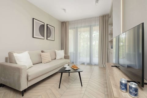 Bright and elegant space with comfortable white sofa, small coffee table, large windows and neutral-colored furnishings.