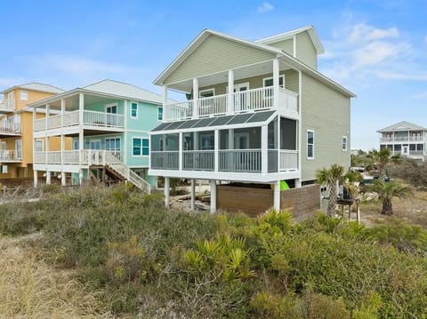 Coastal beachfront rental with spacious screened porch, elevated design, and surrounded by native dunes and palms. Located in a quiet neighborhood steps from the shore.