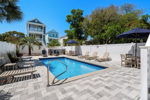 Sparkling pool surrounded by palm trees and lounge chairs, perfect for soaking up the sun during your coastal getaway.