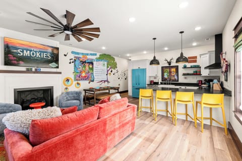 Vibrant open living space with mural, fireplace, and colorful modern kitchen