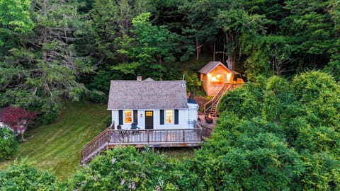 Secluded cottage retreat tucked into the trees with a spacious deck and peaceful wooded surroundings.