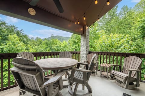Your private covered deck offers stunning mountain views framed by lush forest—perfect for morning coffee or evening unwinding in those comfy chairs.