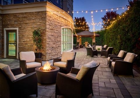 Cozy outdoor patio with a fire pit and string lights.
