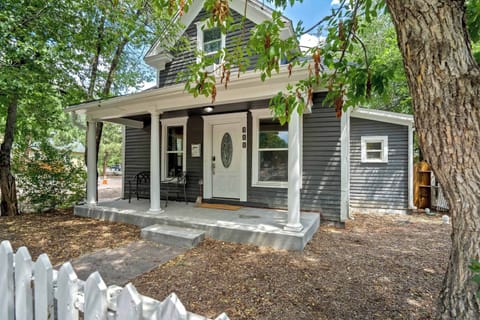 Welcome to Walnut Porch! This lovingly restored 1898 Victorian sits behind a white picket fence on a quiet Westside street, with a covered front porch, a classic gabled roofline, and tall shade trees framing the walkway.