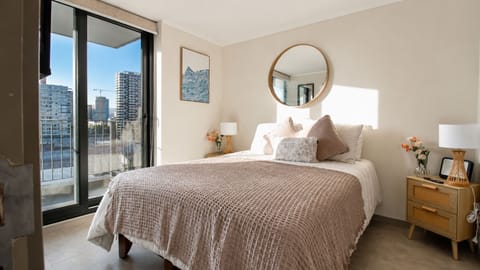 Sunny, stylish bedroom with private balcony and city views