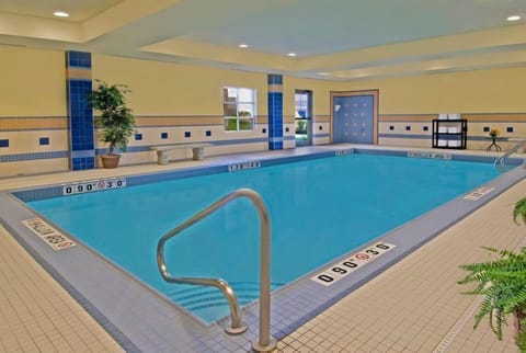 Indoor pool with clear water, non-slip tiling, and natural window light.