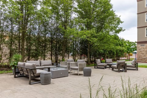 Cosy outdoor lounge with cushioned sectional seating and paved terrace.