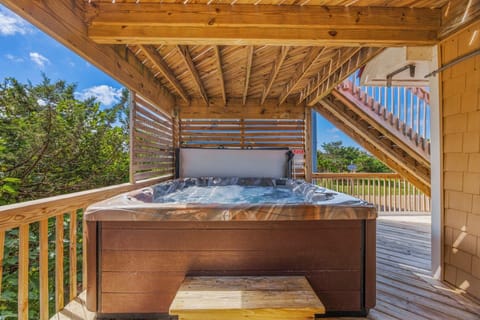 Slip into your private hot tub beneath warm wood beams and let the ocean breeze wash over you. With blue skies overhead, this secluded deck is your perfect spot to unwind.