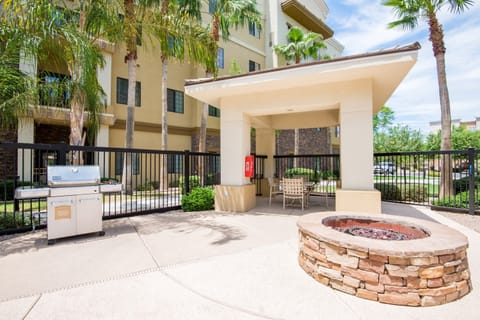 Outdoor grilling area with a fire pit and seating.