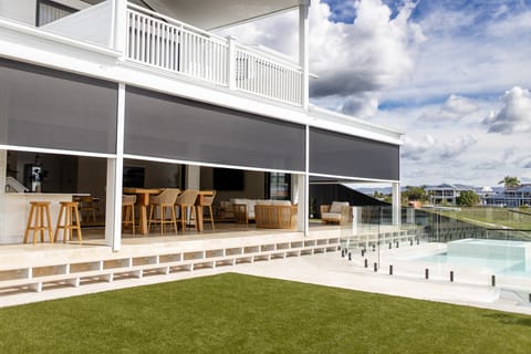 The canal-side elevation: heated pool, covered alfresco and the upstairs terrace