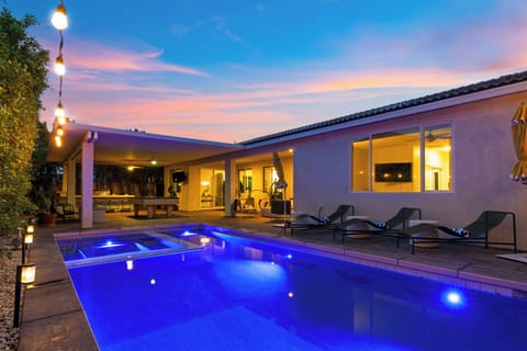 Private pool and lounge area under twilight skies.