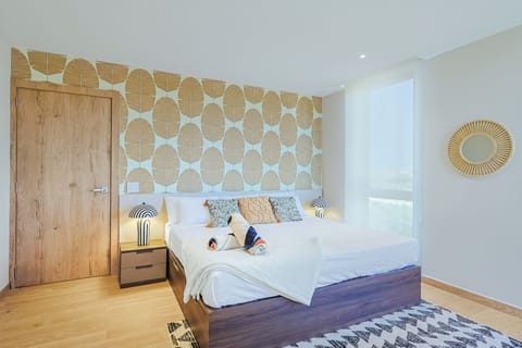 Drift off in your modern, sun-lit bedroom with striking accent wall and plush bedding—your perfect coastal retreat awaits.