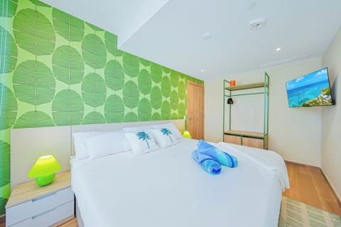 Slip into crisp white sheets beneath a bold leaf-patterned accent wall that brings a touch of tropical energy right to your bedroom sanctuary.