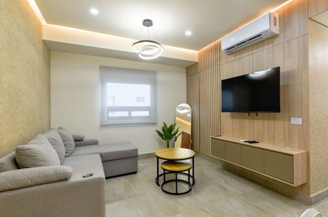 Sala principal con aire acondicionado, Smart TV, sofá cama y mueble de TV. Un espacio cómodo y fresco para relajarte y descansar.