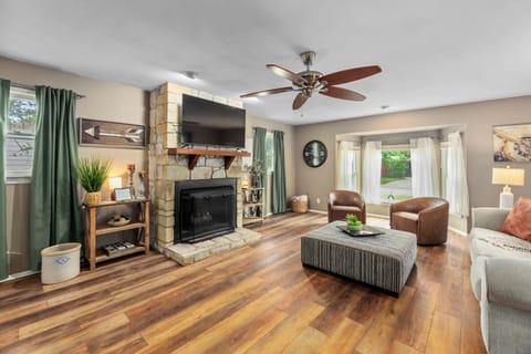 Cozy living room with stone fireplace, TV, and bright natural light