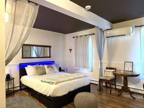Cozy queen bedroom with AC, soft lighting, and extra blankets
