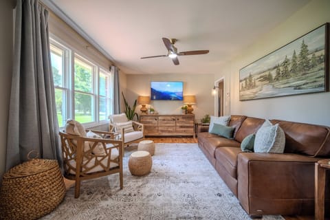 Bright and cozy living room with plenty of natural light, comfortable seating, and a smart TV.