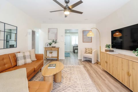 Bright, open-concept living room with relaxed boho décor, comfortable seating, and a smart TV.