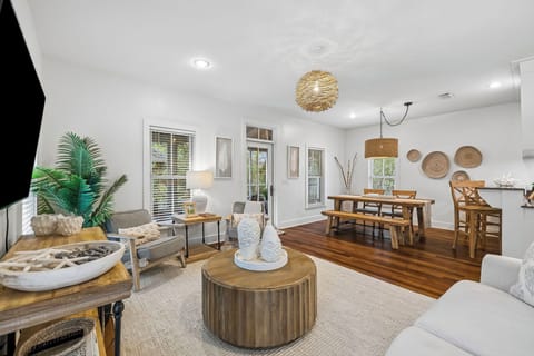 Open living and dining space with comfortable seating and a table for four, filled with natural light.