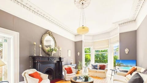 Settle into the elegant front sitting room, where a marble fireplace, tall sash windows and deep armchairs make afternoons in Cheltenham slow down beautifully.