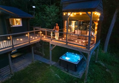 This photo features the glass sun room with lit hot tub.