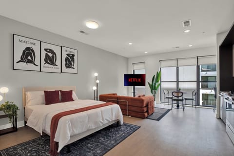 Bright modern studio with cozy lounge, kitchenette, and balcony views