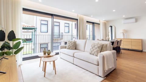 Relax on the plush sofa, bathed in natural light from the expansive balcony doors, offering a connection to the vibrant neighborhood outside. This inviting space is designed for ultimate comfort, whether you're enjoying a quiet moment or planning your nex