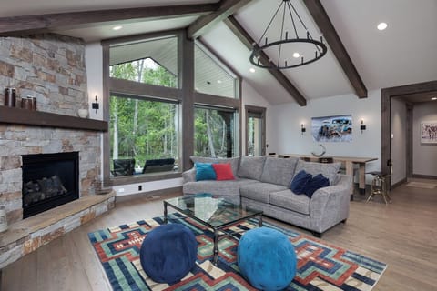 Gather by the stone fireplace beneath soaring, sunlit ceilings.