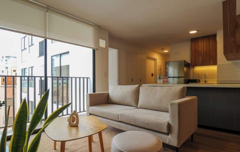 Bright living room with a cozy sofa and private balcony.