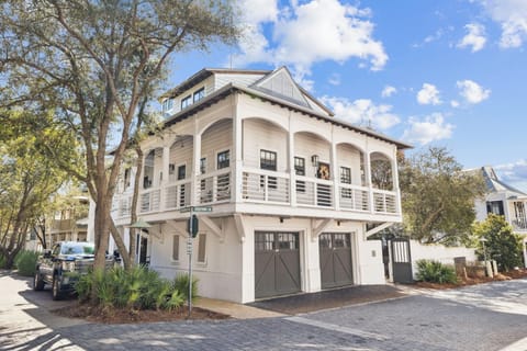 Elegant coastal-style vacation home with covered balcony and garage parking in a charming neighborhood setting.
