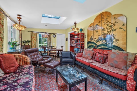 Living and dining space with vibrant patterned furnishings and skylights.
