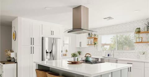 Bright modern kitchen with large island, gas cooktop, and stylish finishes