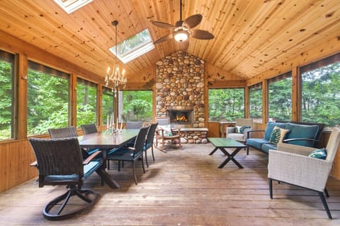 Spacious screened porch with a stone fireplace.