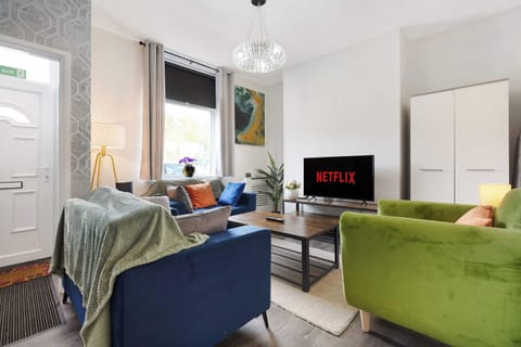 A cosy living room with two comfortable sofas, an armchair and coffee table, offering a welcoming space to relax, unwind and spend time together. The Smart TV provides easy entertainment for quiet evenings.