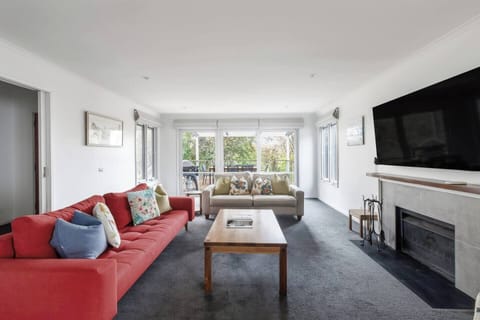 Relax in the light-filled living area with leafy views, a welcoming space for easy conversation or cosy movie nights.