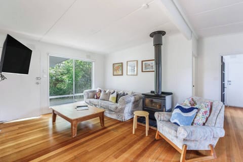 Soft seating, a large-screen TV and bright natural light create an inviting living area where you can unwind after a day exploring Port Phillip Bay.