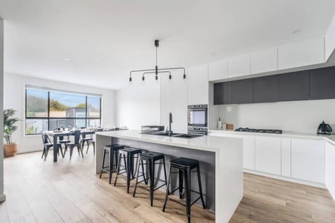 Start the day around the oversized kitchen island, where casual seating creates the perfect spot for coffee, grazing platters, and easy conversation.
