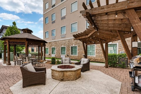Unwind around the stone fire pit under the wooden pergola strung with string lights.