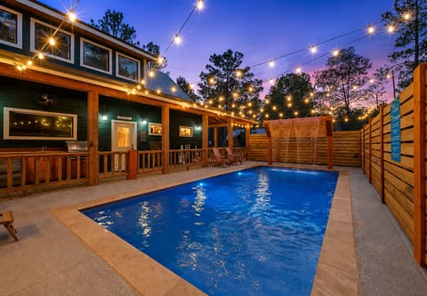 Private pool oasis with string lights and cozy cabin ambiance