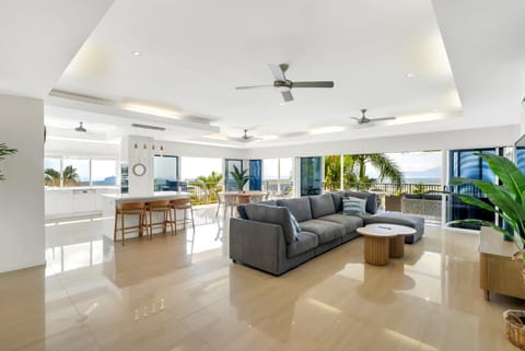 Unwind in the living area while expansive windows draw your eye across lush greenery to the distant mountains beyond.
