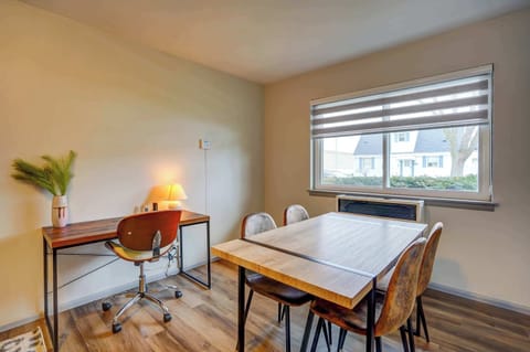 Bright, functional space featuring a work desk and a dining table for four—ideal for remote work, study sessions, or shared meals in a relaxed setting.