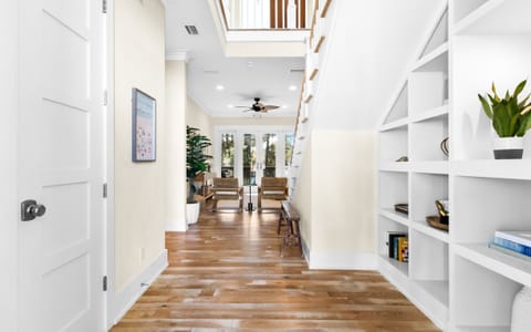 Bright entryway with hardwood floors, built-ins, and airy open staircase